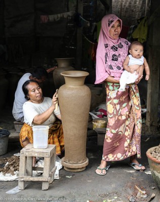 Woman making a tall pot with a younger woman holding a baby, Banyu Mulek, Lombok, Indonesia
