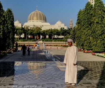 Our guide Yaqoob poses in front of the Sultan Qaboos Grand Mosque gardens